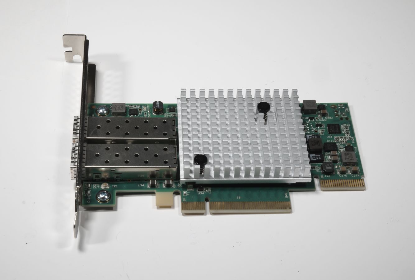 A standard PCIe card with two SFP+ cages on the left by the bracket, and a low-profile aluminium heatsink in the middle, attached with push-pins. The card is quite long because of the voltage regulator circuitry on the right.