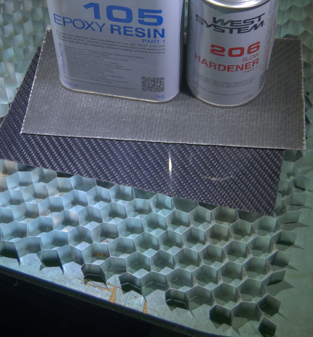 A large section of aluminium honeycomb, two small sheets of carbon fibre, and tins of epoxy.