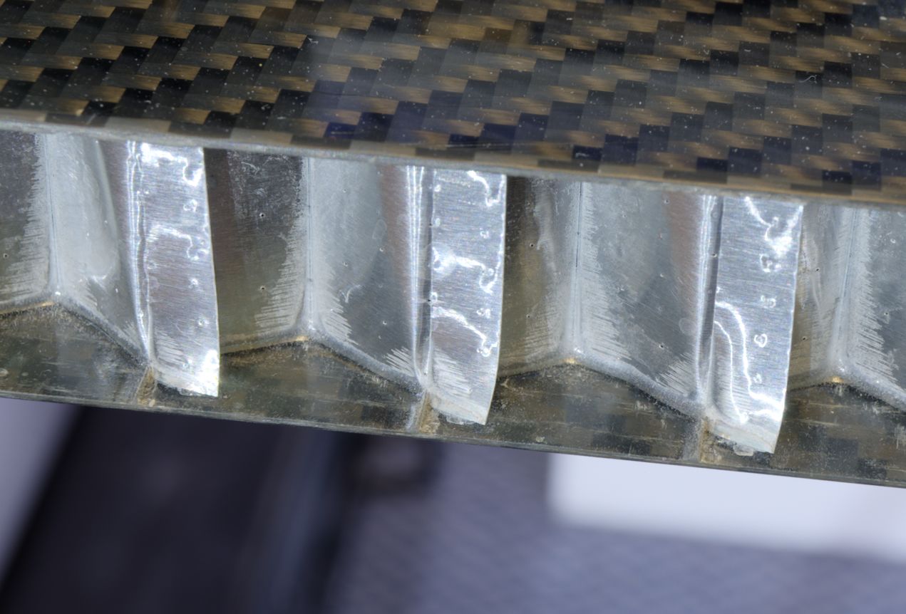 A close-up of the edge of the panel, showing how the aluminium has bonded to the carbon.