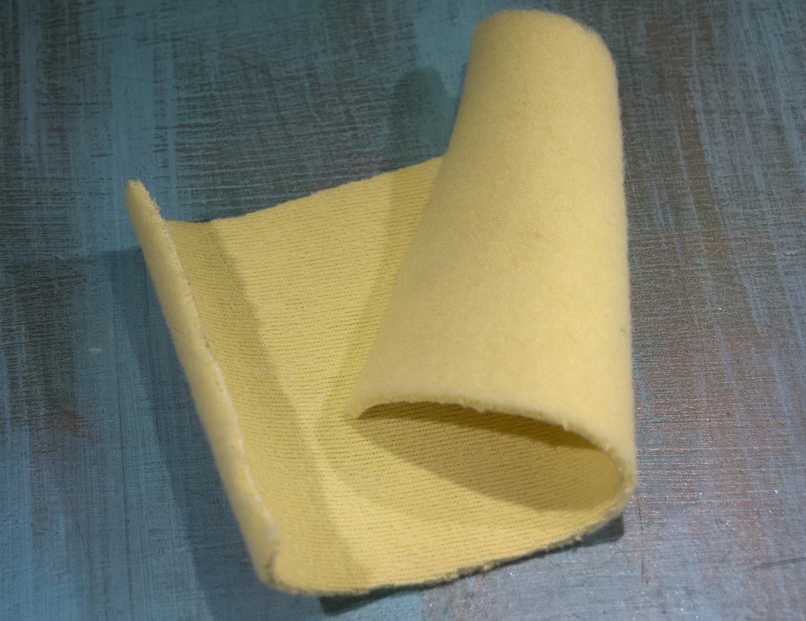 A piece of Kevlar fleece, smooth on one side, fluffy on the other. It's yellow - Kevlar's natural colour.